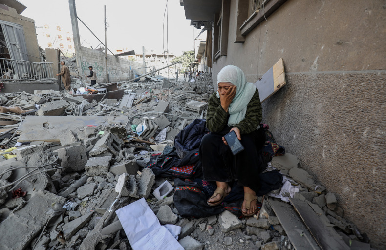 Woman sitting on top of a destroyed building